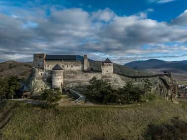 Aerial view of partially restored Boldogko, medieval Gothic castle in Borsod county Hungary with round gate tower, donjon cloudy blue sky background