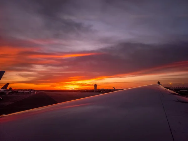 飞机降落在华盛顿杜勒斯并经过控制塔时 天空呈橙色 美丽的落日景象 — 图库照片