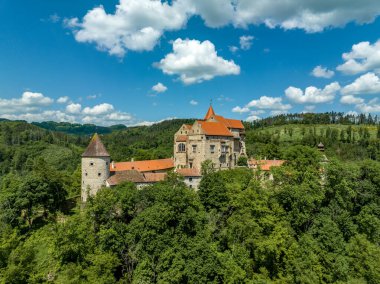 Pernstejn kalesinin Gotik sarayı kırmızı çatısı, dikdörtgen ve yuvarlak kuleleri, barbikalı, Moravya 'daki ileri silah platformu