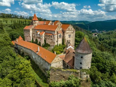 Pernstejn kalesinin havadan görünüşü Gotik sarayı kırmızı çatısı, dikdörtgen ve yuvarlak kuleleri, barbikalı, Moravya 'daki ileri silah platformu