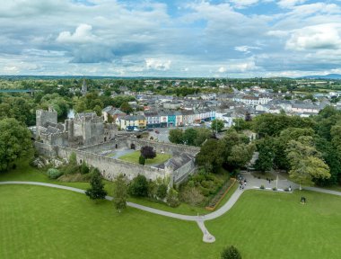 İrlanda 'daki Cahir şatosu ve kasabasının havadan görünüşü. Kule Kulesi, dış kale, dairesel, dikdörtgen kuleler, banket salonu, Suir Nehri' ndeki geçişi koruyan şelale ve golf sahası.