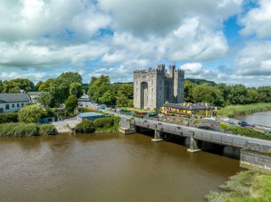 Bunratty Kalesi 'nin havadan görünüşü İrlanda' nın Clare ilçesindeki 15. yüzyıldan kalma büyük bir kule evi Ralty nehrinin geçidini Shannon nehrine ulaşmadan koruyor.