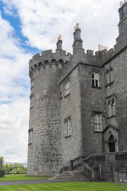 Kilkenny Kalesi 'nin havadan görünüşü, ortaçağ savunma yapısının yeniden yapılandırılması, yuvarlanan parklar, teraslı gül bahçesi, ağaçlık alanlar, Nore Nehri kıyısında insan yapımı göl.