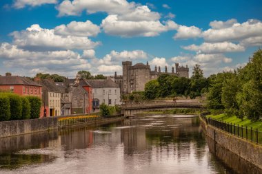 Kilkenny Kalesi 'nin havadan görünüşü, ortaçağ savunma yapısının yeniden yapılandırılması, yuvarlanan parklar, teraslı gül bahçesi, ağaçlık alanlar, Nore Nehri kıyısında insan yapımı göl.