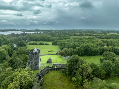 İrlanda 'daki Aughnanure şatosunun havadan görünüşü. Çok katlı büyük bir ev bakımı, Gotik saray büyük salon ve su dolu hendek.
