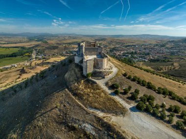 İspanya 'nın Guadalajara eyaletindeki Jadraque ortaçağ tepe şatosunun Henares nehrinin yukarısındaki Henares Nehri' nin üzerinde, jet akıntıları ile mavi gökyüzü.