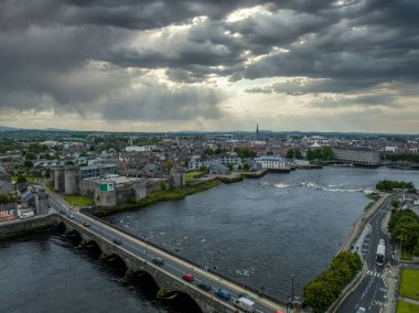 Limerick İrlanda 'daki Kral John kalesi Shannon nehrinin kıyısında Thomond köprüsünün yanında dramatik bulutlu gökyüzü