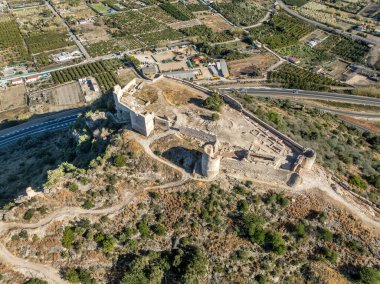 İspanya 'da Gandia yakınlarındaki Bairen Ortaçağ kalesinin havadan görünüşü kısmen yenilenmiş bulutlu gökyüzü dairesel kuleleri ile harabeye döndü