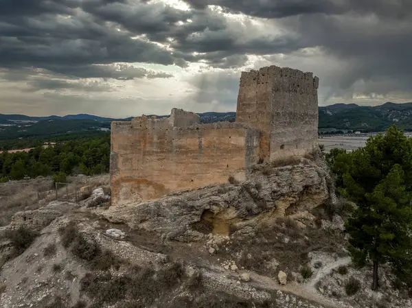 Aerial view of Barxell castle in the municipality of Alcoy, Alicante, Spain. 13th century medieval building standing on a rocky mound in the middle of a pine forest in the valley of Polop. Rectangular great tower ruined palace building