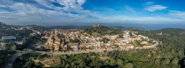 16. yüzyıl Begur kalesinin havadan görünüşü, Akdeniz 'in panoramik manzaralı ormanlık bir tepenin üstünde. Korsanlara karşı inşa edilen kuleleri izleyin.