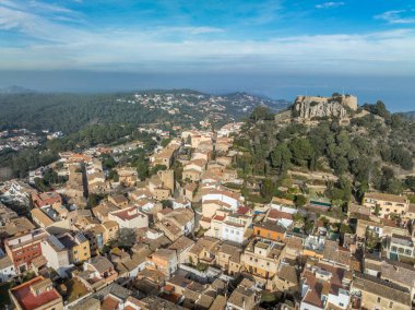 16. yüzyıl Begur kalesinin havadan görünüşü, Akdeniz 'in panoramik manzaralı ormanlık bir tepenin üstünde. Korsanlara karşı inşa edilen kuleleri izleyin.