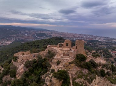 11. yüzyıldan kalma küçük bir Burriac kalesinin hava günbatımı manzarası, bir tepedeki şapel, mütevazı bir yürüyüş ve dramatik manzarası var.