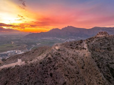 Murcia 'daki Orihuela' nın havadan görünüşü. Şatosu, Gotchic ve Barok kiliseleri ile İspanya 'nın ortaçağ kasabası. Segura nehrinin yanında dramatik renkli günbatımı gökyüzü.