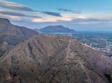 İspanya 'nın Alicante eyaletindeki Orihuela şatosunun havadan görünüşü harap olmuş ortaçağ tepe duvarları ve kısmen restore edilmiş kuleleri