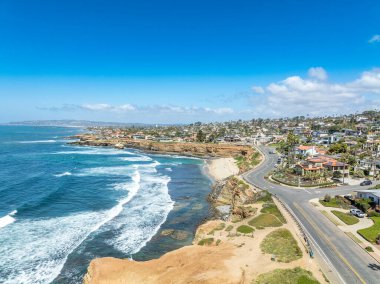 San Diego 'da Sunset Sahili' nin havadan manzarası. Pürüzlü Kaliforniya okyanus kıyıları, ezici dalgalar, lüks aile evleri ve havuzlu evler.