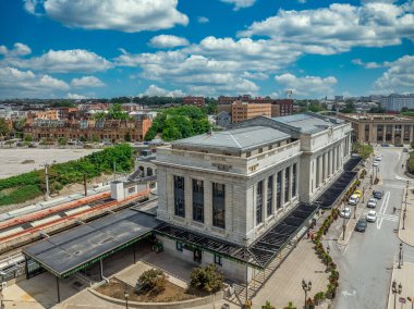 Baltimore Penn İstasyonu 'nun havadan görünüşü, klasik Doğu Yakası tren istasyonu banliyö ve bulutlu arka planı olan yolcu trenleri.