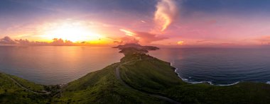 St. Kitts, Basseterre, Güney Friars Körfezi renkli güneş ışınları üzerinde dramatik bir gün batımı. Güneş Karayip Denizi 'nin üzerinde batarken bulutları pembeye, kırmızıya ve mora boyuyor. 