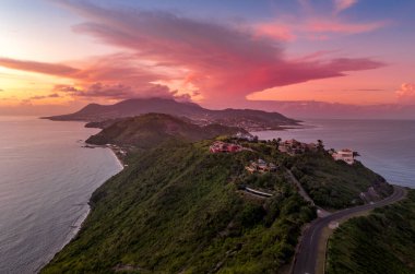 St. Kitts, Basseterre, Güney Friars Körfezi renkli güneş ışınları üzerinde dramatik bir gün batımı. Güneş Karayip Denizi 'nin üzerinde batarken bulutları pembeye, kırmızıya ve mora boyuyor. 