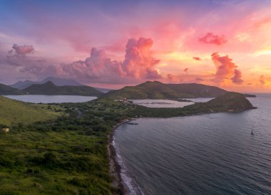 Christophe Limanı, St. Kitts ve Nevis, Karayipler 'de palmiye ağaçları ve büyüleyici günbatımıyla pembe, mor ışık bulutları boyuyor.  