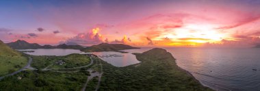 Christophe Limanı, St. Kitts ve Nevis, Karayipler 'de palmiye ağaçları ve büyüleyici günbatımıyla pembe, mor ışık bulutları boyuyor.  