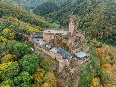 Aerial view of Ehrenburg medieval spur castle with fall foliage in Germany near the Moselle river, dramatic sunset with colorful sky, tall keep, bailey, round towers clipart