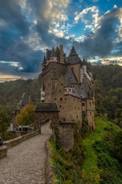 Burg Eltz romantizmi Almanya 'da dramatik gün batımı kulesi ve gökyüzü kuleleri ile Gotik kaleyi restore etti