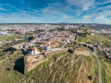 Aerial view of the castle of Estremoz in Portugal dominated by a square keep built from white marble, surrounded by four gates, bastions, ravelins and other defensive structures clipart