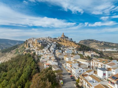 Aerial view of Iznajar castle white village in Andalucia, triangular design, wall with flanking towers, pentagonal keep in one of Spain's most beautiful villages above a reservoir clipart