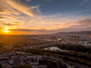 Roma köprüsünün üzerinde renkli günbatımı gökyüzü, şehir merkezinde ortaçağ katedrali olan Cordoba İspanya 'nın hava manzarası.