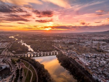 Roma köprüsünün üzerinde renkli günbatımı gökyüzü, şehir merkezinde ortaçağ katedrali olan Cordoba İspanya 'nın hava manzarası.