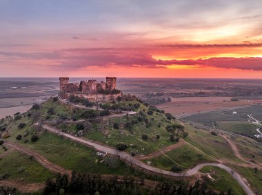Almodovar del Rio İspanya üzerindeki Almodovar şatosunun havadan görünüşü, yenilenmiş kuleleri olan Gotik Mudejar stili, günbatımı gökyüzü
