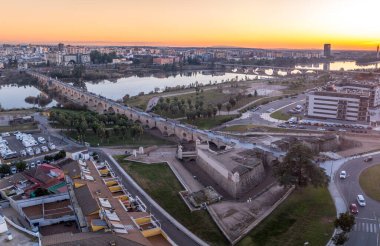 Badajoz Palmas Köprüsü 'nün baş kornosu çalışmasının hava görüntüsü, gün batımında dışarı bakan iki yarım kale ve Roma köprüsü.