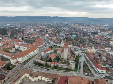 Şehrin ortasında duvarları ve kuleleri olan Aiud Nagyenated Protestan kilisesinin havadan görünüşü