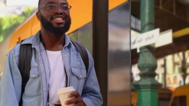 Avrupalı bir terminalde kahve içen genç bir Afrikalı 'nın düşük açılı görüntüsü. Tatil tatili için hafta sonu seyahati..