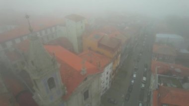 Portekiz 'in Porto şehrinde tipik bir kilise ve sisli caddenin sisli hava manzarası