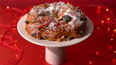 Portekiz Bolo Rei geleneksel bir Noel pastası. Meyveli ve kırmızı arka planda kremalı.