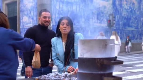 Portugal Portugal 2022年11月15日 年轻夫妇在典型的带有Azulejo背景的葡萄牙街头购买烧烤栗子 — 图库视频影像