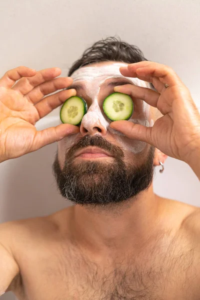 Stock image Bearded man put on cucumber on front of his eyes while relaxing in bath at home