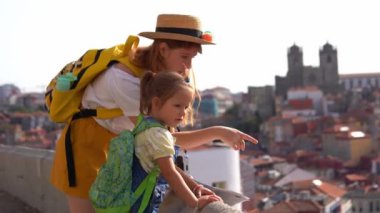 Happy family traveling. Young red-haired mother and little daughter looking on the Porto city, Portugal