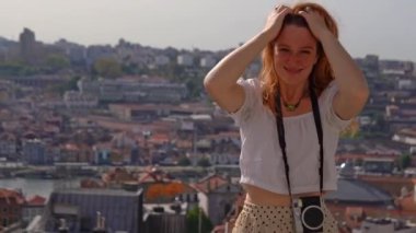 Happy Young tourist woman enjoying a vacation in Europe against the view of the cityscape of old Porto town, Portugal