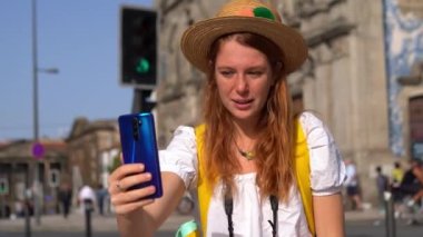 Kızıl saçlı genç bir turist Portekiz Caddesi 'ndeki bir telefondan arıyor. Avrupa 'da tatilin tadını çıkarıyorum. Turizm ve seyahat kavramı.