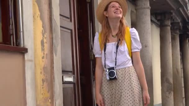 古いヨーロッパの町を歩いてカメラを持つ若い観光客の女性 ヨーロッパでの休暇を楽しんで — ストック動画
