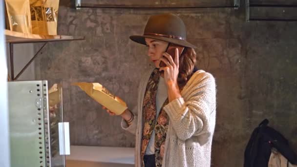 Młoda Europejska Bizneswoman Rozmawiająca Przez Telefon Trzymająca Paczkę Suchych Grzybów — Wideo stockowe