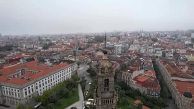 Portekiz 'in Porto şehrinin ünlü şehir simgesi Clerigos Kilisesi Barok Çan Kulesi' nin kasvetli sabahında daire şeklinde hava manzarası.