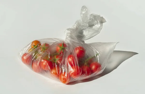 透明なビニール袋の中のチェリートマト 白い背景のパッケージに赤い小さなトマト — ストック写真