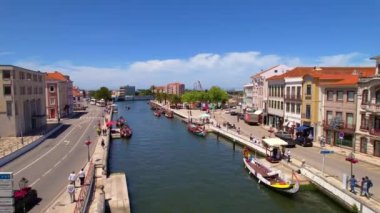 Aveiro, Portekiz - 21.05.2022: Aveiro şehir merkezindeki eski şehir barajındaki moliceiro tekneleriyle kanal yakınlarındaki tipik Portekiz evlerinin hava manzarası