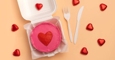 Sevgililer günü bento keki Bıçak, çatal ve kalp şeklinde şekerlemelerle bej arka planda, düz uzanmış