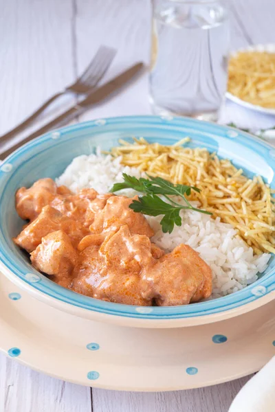Beyaz ahşap masada pilav ve patates pipetli Chicken Strogonoff yakın çekim. Brezilya mutfağı..