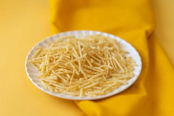 Batata palha - potato straw on yellow paper background. close-up