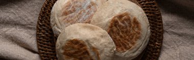 Traditional Portuguese flat circular bread Bolo Do Caco on textile background. Madeira island cuisine. Top view.